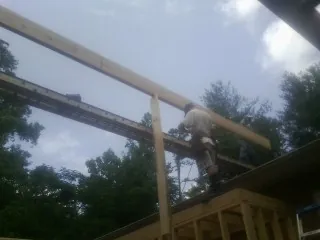 Carpenter setting a ridge beam over a new addition frame — Ice Dam Removal by Roofing Brothers in Terreton