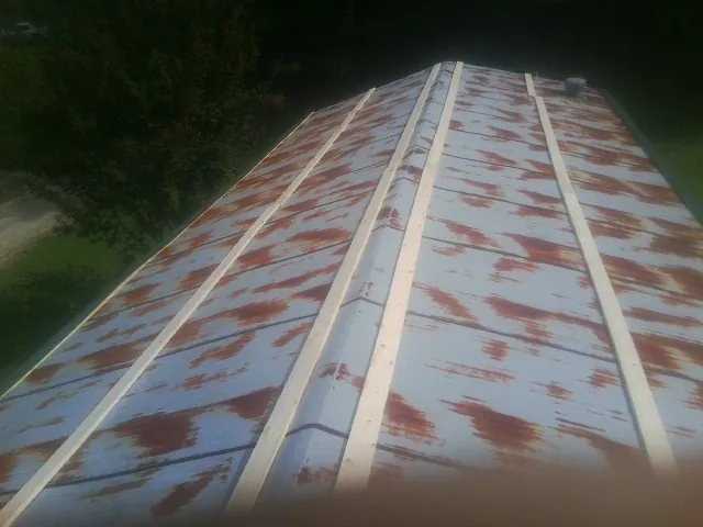 Rusted metal roof panels with new wood purlins before replacement — Storm Damage Roof Repair in Terreton by Roofing Brothers