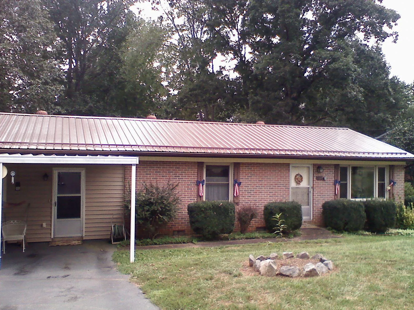 Bronze metal roof and carport on a brick ranch home — Roof Repair work by our crew in Terreton